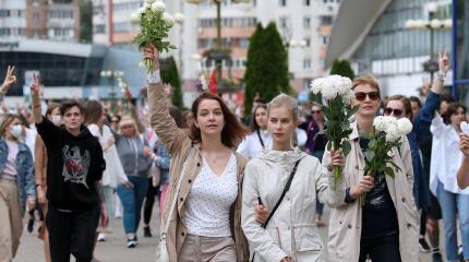 "Верим, можем, победим!". Девушки с белыми цветами вышли на улицы Минска