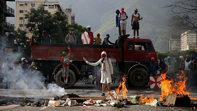 В Венесуэле протестующие жгут полицейские участки и машины